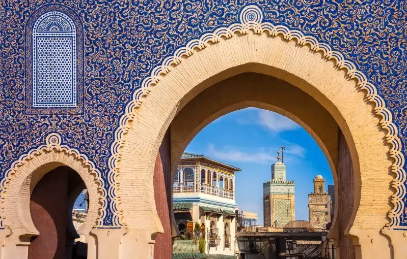 The ornate entrance to a mosque in Fes, Morocco, showcasing intricate architectural details and vibrant colors.Fes Morocco attractions